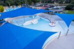 Shaded shallow splash pool at Werribee Outdoor Pool with blue sail covers.