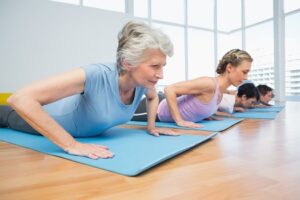 Senior women performing modified push-ups on yoga mats during a gentle fitness class at WynActive.