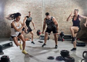 High-intensity workout class with participants doing fast-paced strength and cardio drills.