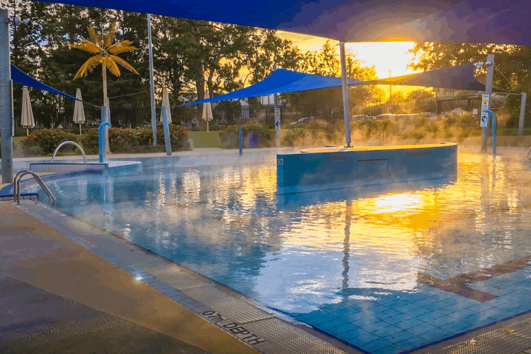 Outdoor heated pool at Werribee Outdoor Pool with steam rising at sunrise.